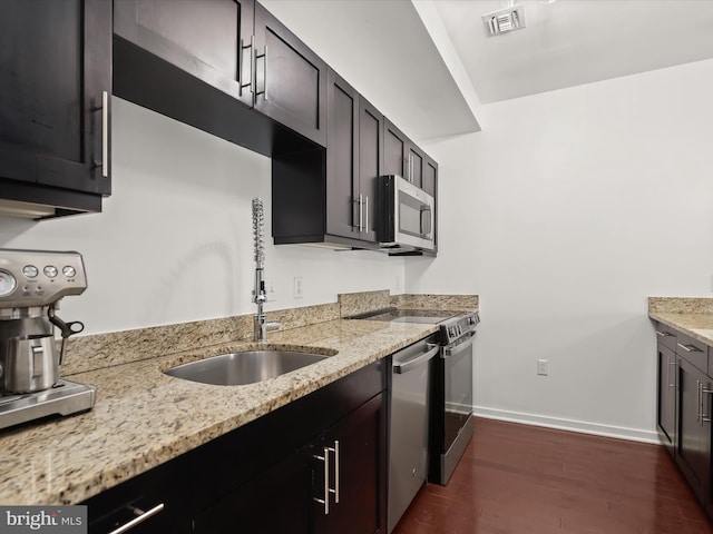 kitchen with visible vents, a sink, dark wood-style floors, appliances with stainless steel finishes, and baseboards