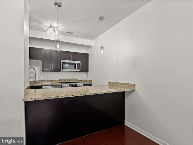 kitchen with dark wood-style floors, visible vents, a peninsula, and stainless steel appliances