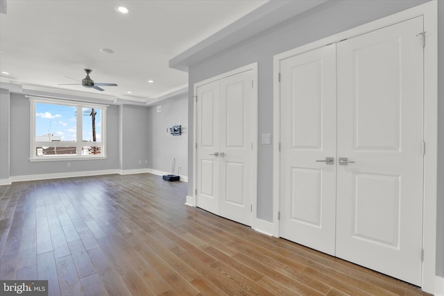 interior space with ceiling fan, light wood-type flooring, and two closets