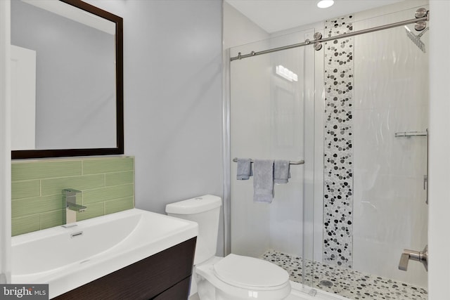 bathroom featuring vanity, toilet, walk in shower, and tasteful backsplash