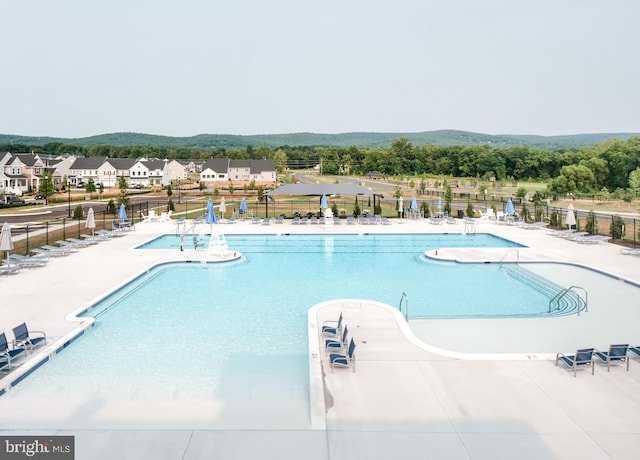 view of pool featuring a mountain view and a patio