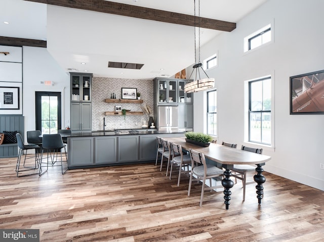 dining space with beam ceiling and hardwood / wood-style flooring