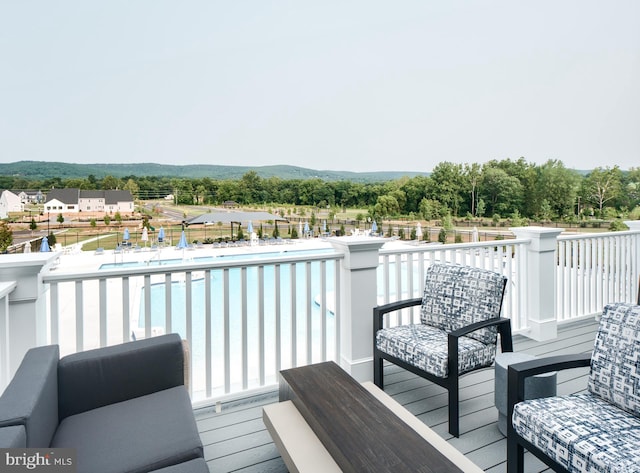 wooden terrace featuring a fenced in pool