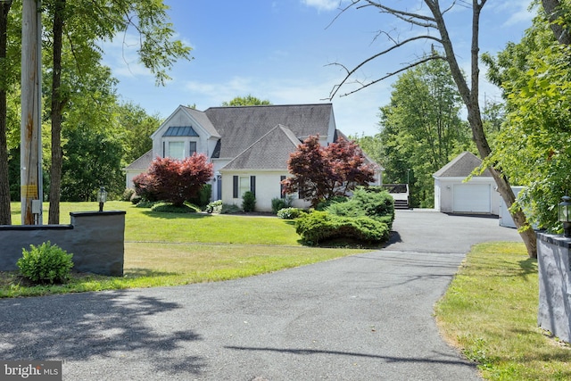 view of front of property featuring an outbuilding, a front lawn, and a garage