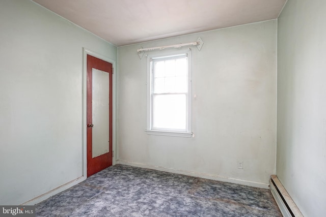 spare room featuring baseboard heating and carpet