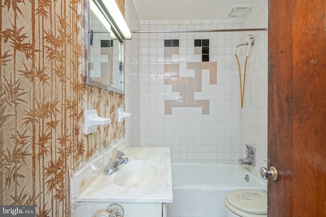 full bathroom with toilet, vanity, and tiled shower / bath