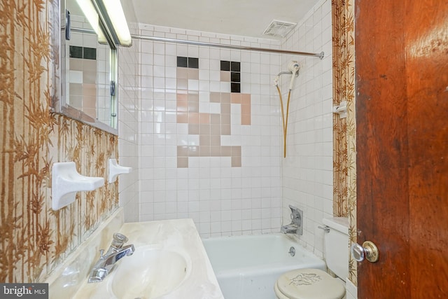 full bathroom featuring sink, toilet, and tiled shower / bath combo