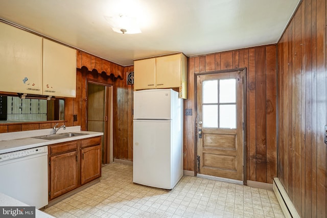 kitchen featuring sink, wood walls, a baseboard radiator, and white appliances