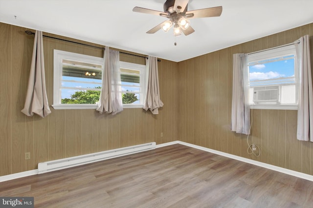 spare room with baseboard heating, a wealth of natural light, ceiling fan, and cooling unit