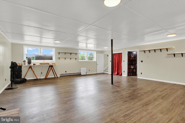 basement with hardwood / wood-style flooring and a baseboard heating unit