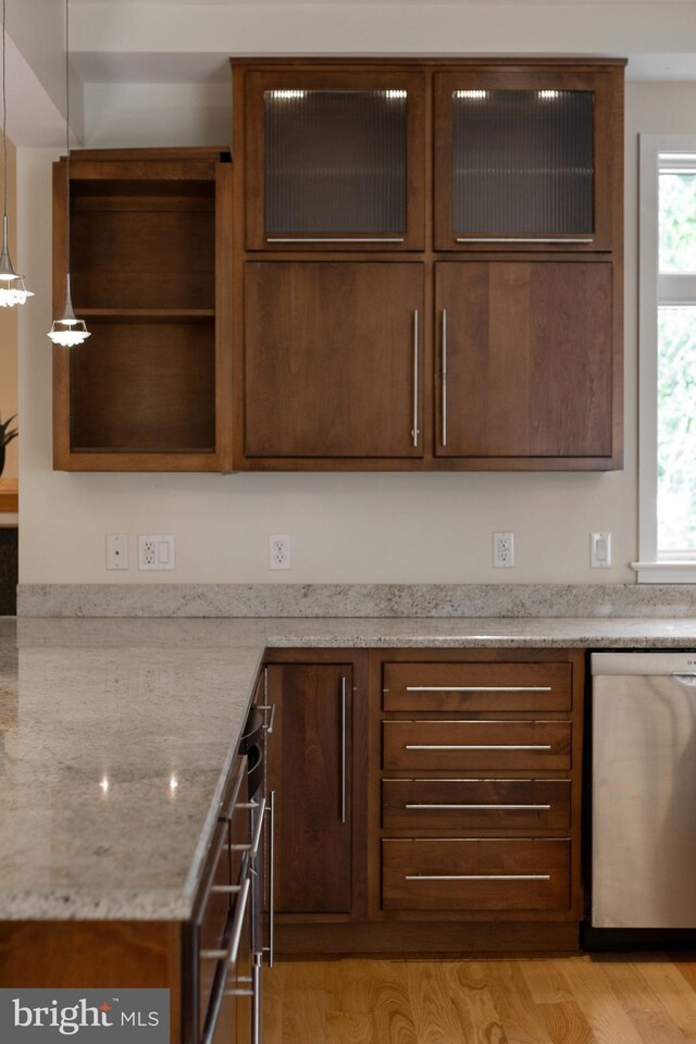 kitchen with island exhaust hood, a center island, light stone counters, light hardwood / wood-style floors, and stainless steel appliances