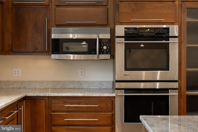 kitchen featuring light stone countertops and stainless steel appliances