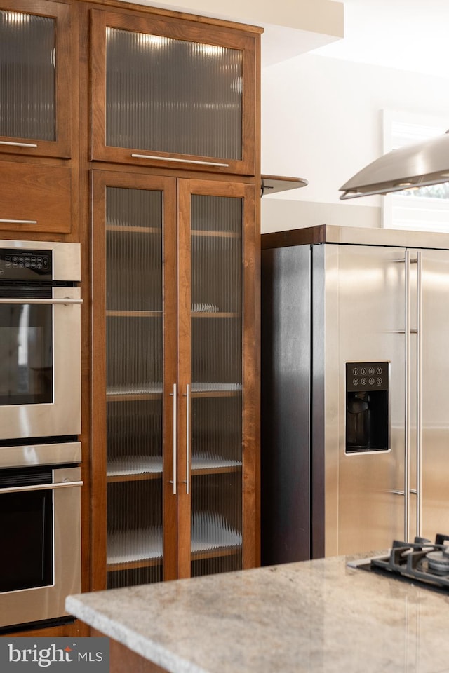 kitchen with light stone countertops and stainless steel appliances