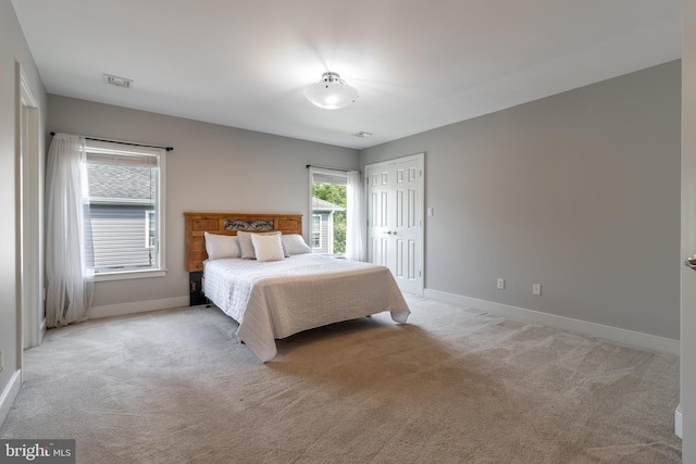 bedroom with light colored carpet and a closet