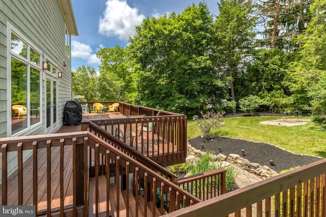 wooden terrace with a grill and a yard