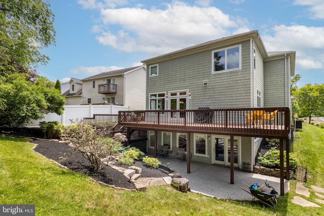 rear view of house with a patio area, a lawn, and a deck