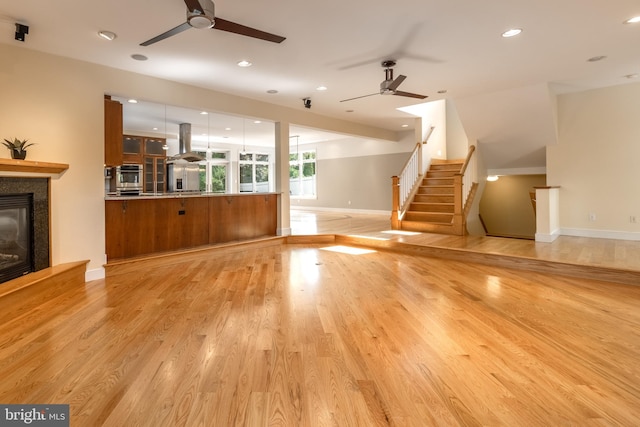 unfurnished living room with light hardwood / wood-style flooring and ceiling fan