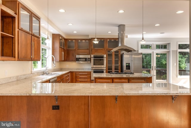 kitchen with sink, island range hood, hanging light fixtures, appliances with stainless steel finishes, and kitchen peninsula