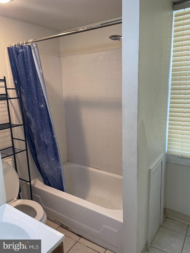 bathroom featuring tile patterned flooring, shower / bath combo, and toilet