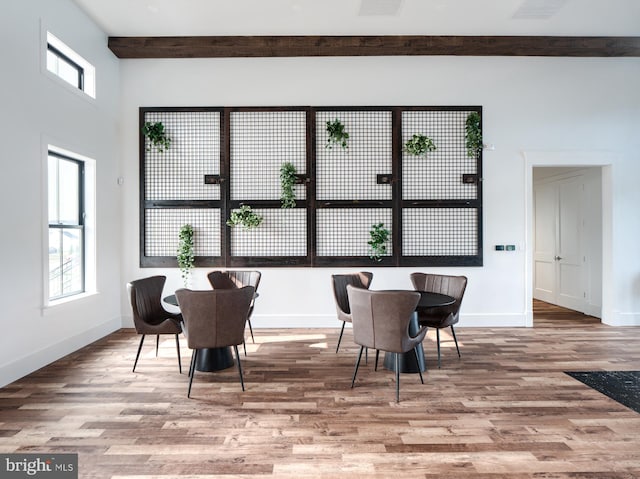 dining area with beamed ceiling and hardwood / wood-style flooring