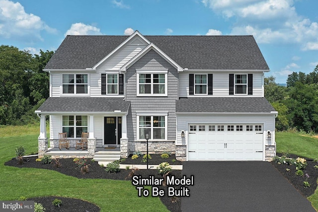 view of front of house with a garage, a front lawn, and covered porch