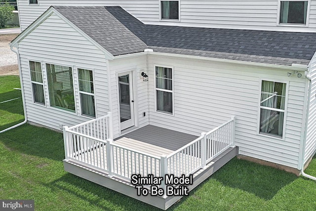 rear view of house featuring a yard and a wooden deck