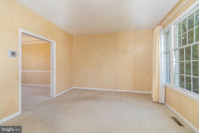 unfurnished room featuring light carpet