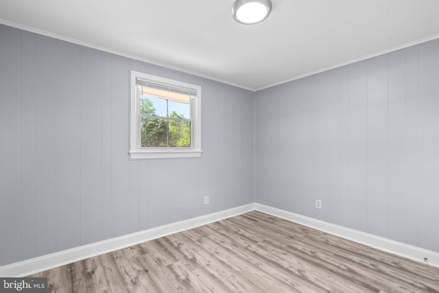 unfurnished room with crown molding and light wood-type flooring