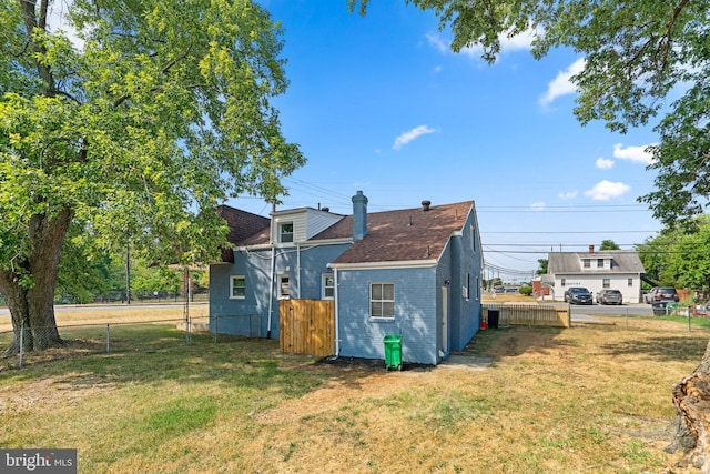 rear view of property with a yard