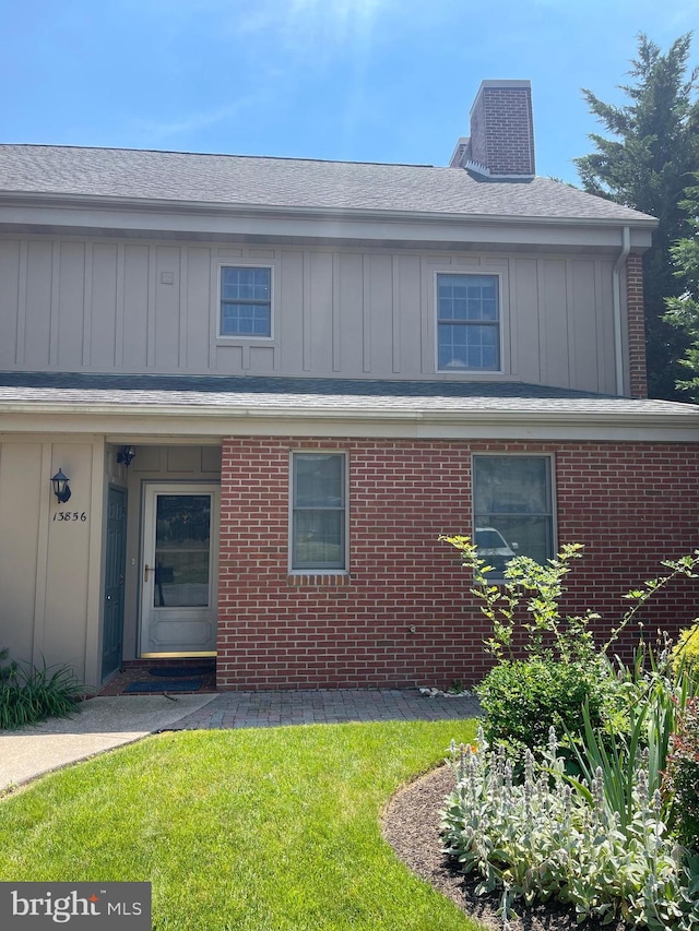 view of front of property featuring a front lawn and central AC