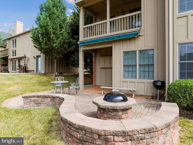 view of patio with a balcony, an outdoor fire pit, and a grill