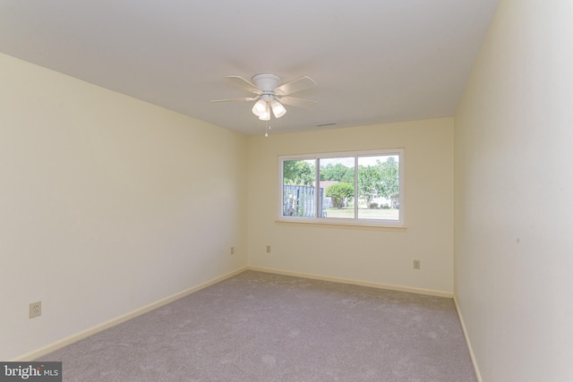 spare room with ceiling fan and light colored carpet