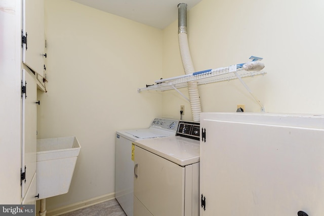 clothes washing area with washer and dryer and sink