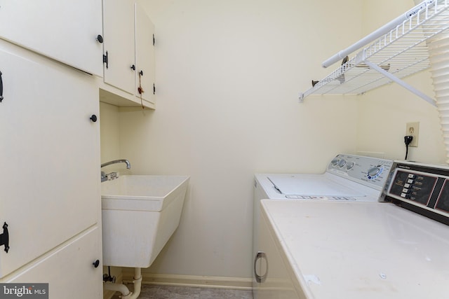 washroom with washer and clothes dryer, cabinets, and sink