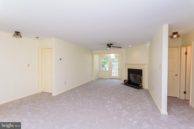 unfurnished living room featuring ceiling fan and light carpet