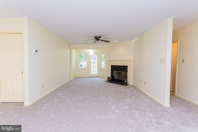 unfurnished living room featuring light colored carpet and ceiling fan