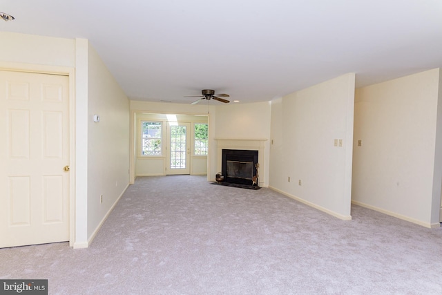 unfurnished living room with ceiling fan and light carpet