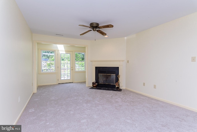 unfurnished living room featuring ceiling fan and light colored carpet