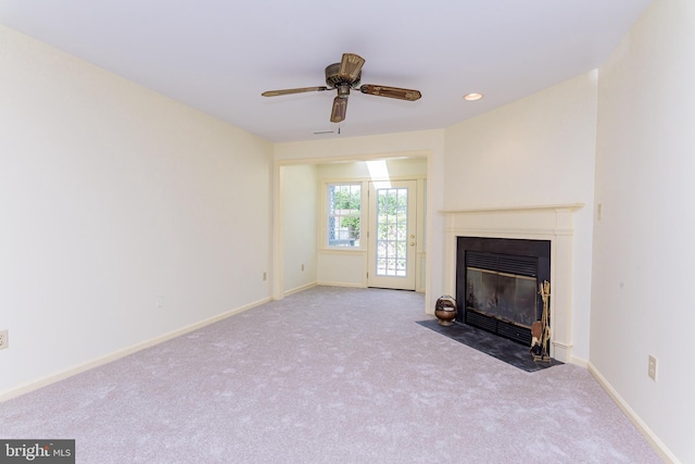 unfurnished living room featuring ceiling fan and light colored carpet