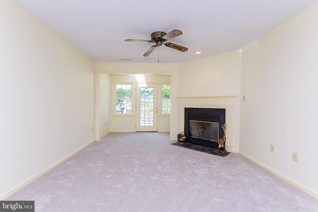 unfurnished living room featuring ceiling fan and light colored carpet