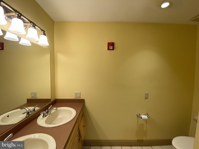 bathroom with tile patterned flooring, vanity, and toilet