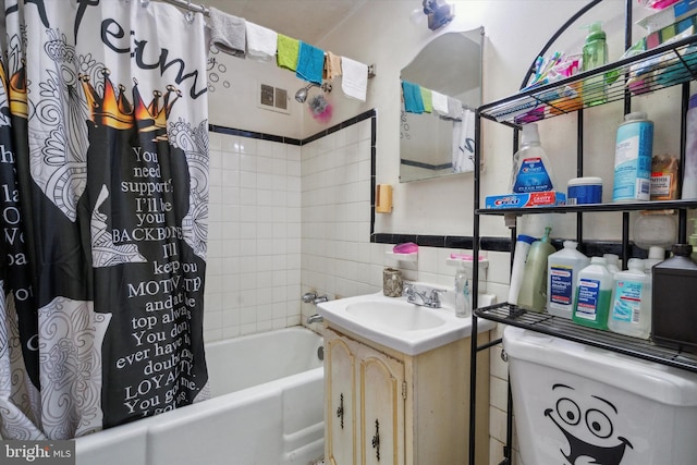 full bathroom with shower / tub combo, tile walls, toilet, and vanity