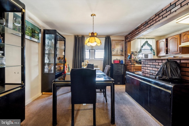 carpeted dining space featuring brick wall