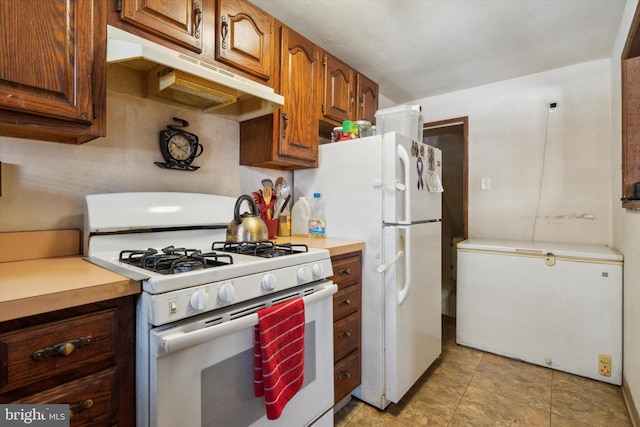 kitchen with light tile patterned flooring, extractor fan, and white appliances