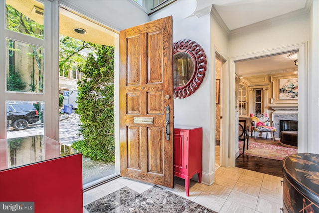 entryway with a premium fireplace, ornamental molding, and light hardwood / wood-style flooring