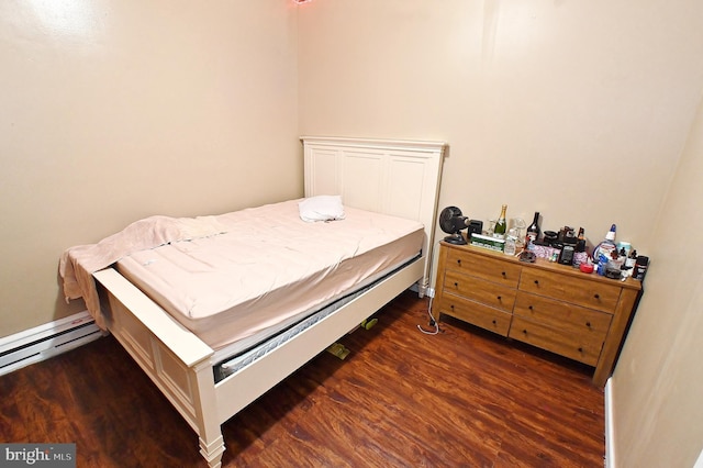 bedroom with dark wood-type flooring and a baseboard heating unit