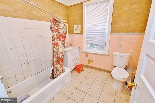 full bathroom featuring shower / bath combo, tile patterned flooring, toilet, vanity, and tile walls