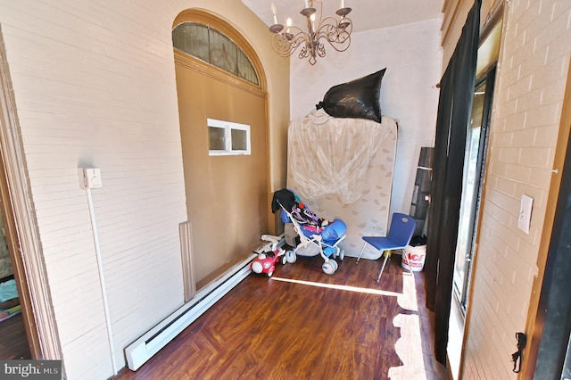 interior space with dark hardwood / wood-style floors, a baseboard heating unit, and an inviting chandelier