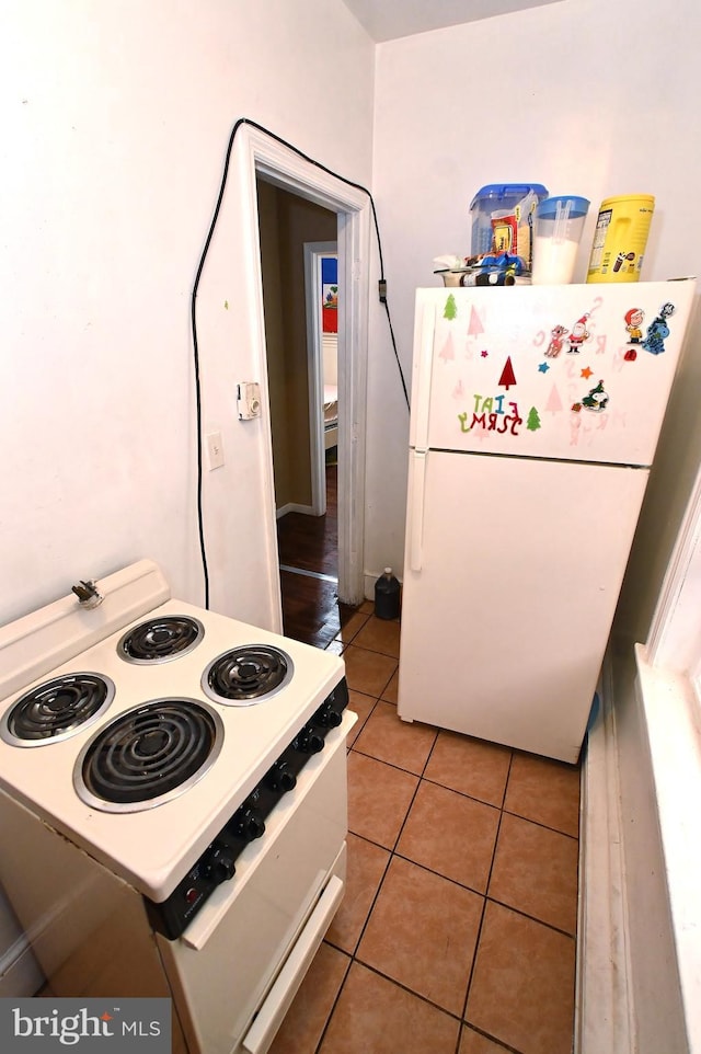 kitchen featuring white appliances and light tile patterned flooring