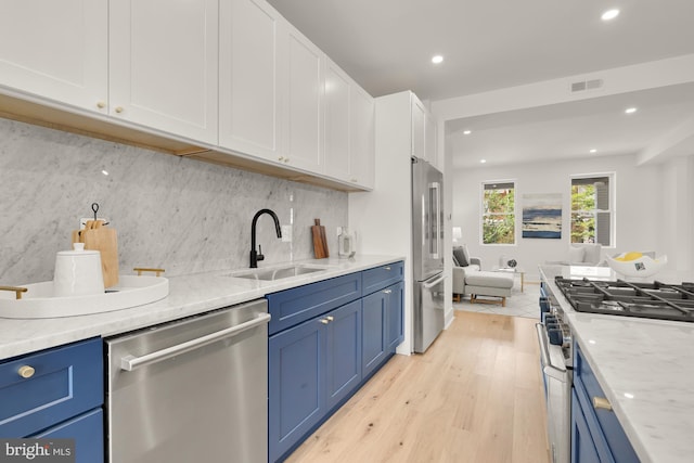 kitchen featuring blue cabinets, sink, light hardwood / wood-style flooring, high quality appliances, and white cabinets